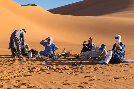 Tuareg at campsite in the sand dunes of In Tehak, Tadrart region, Tassili n ́Ajjer National Park, Sahara, North Africa