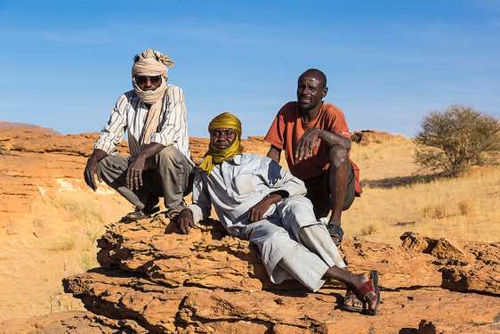 Driver Mohamed, local guide Haraoun, driver Osman (left to right) taking it easy, Labyrinthe d'Oyo, Ennedi Mountains, northeastern Chad