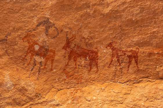Rock painting depicting a row of red goats and a dark red human figure, Kozen rock art site, Tibesti region