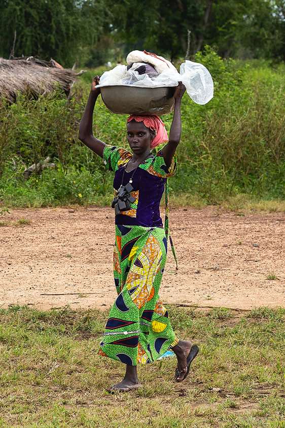 Woman balancing a bowl of laundry on her head