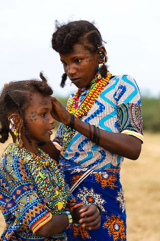Wodaabe (Bororo) woman braiding a girls's hair at the Gerewol festival