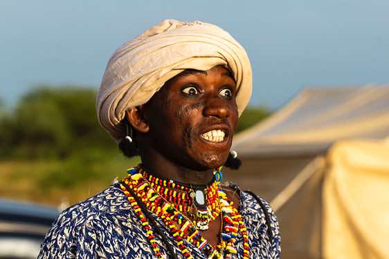 Wodaabe (Bororo) man rolls his eyes and shows his teeth to impress spectators, in particular women
