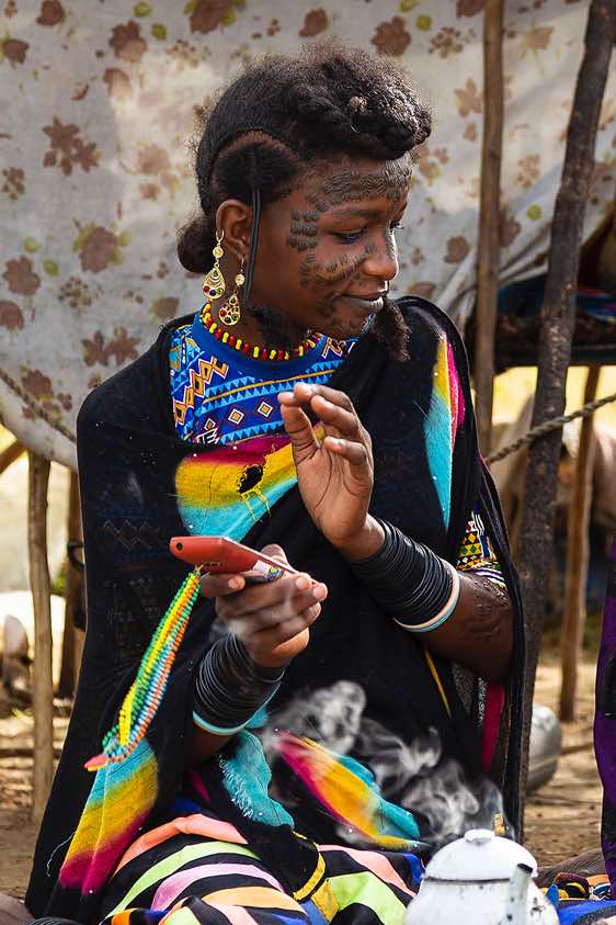 Wodaabe (Bororo) woman with mobile phone at campsite, Gerewol festival
