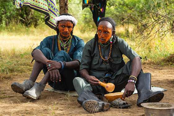 Wodaabe (Bororo) men having a meal at their campsite, Gerewol festival