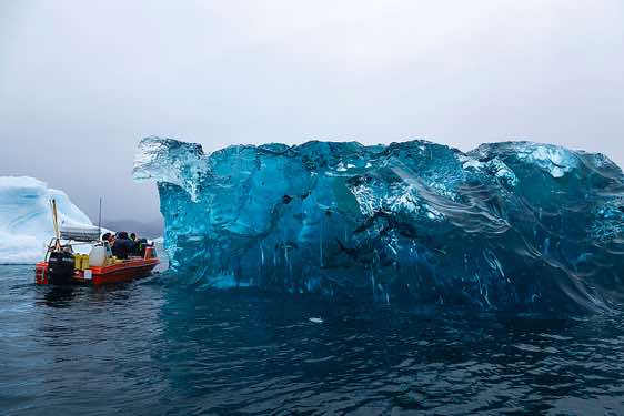 Boat approaching a huge block of ice, Sermilik Fjord