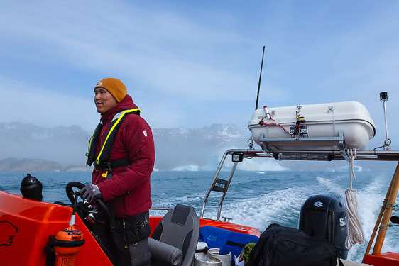 Inuit steering the boat en route to Sermilik Fjord, Ammassalik Island