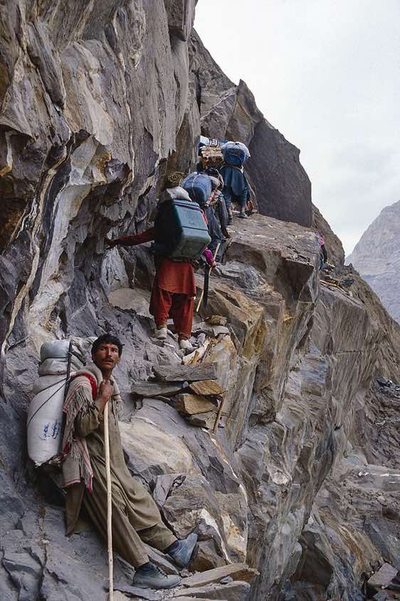 Porters on a trail high above the valley floor, Karakoram Mountains