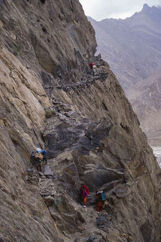 Porters on a trail high above the valley floor, Karakoram Mountains