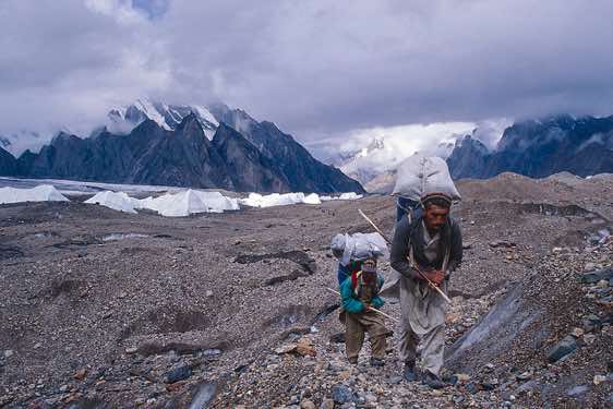 Two porters with their payloads on the Baltoro Glacier, Karakoram Mountains
