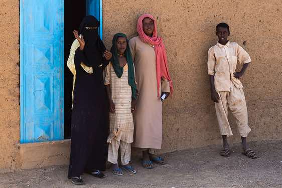 Teacher, Bisharin nomad girls and boy in front of local school, Bayuda Desert, Northern Sudan