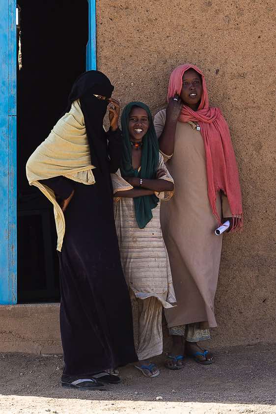Teacher and Bisharin nomad girls in front of local school, Bayuda Desert, Northern Sudan