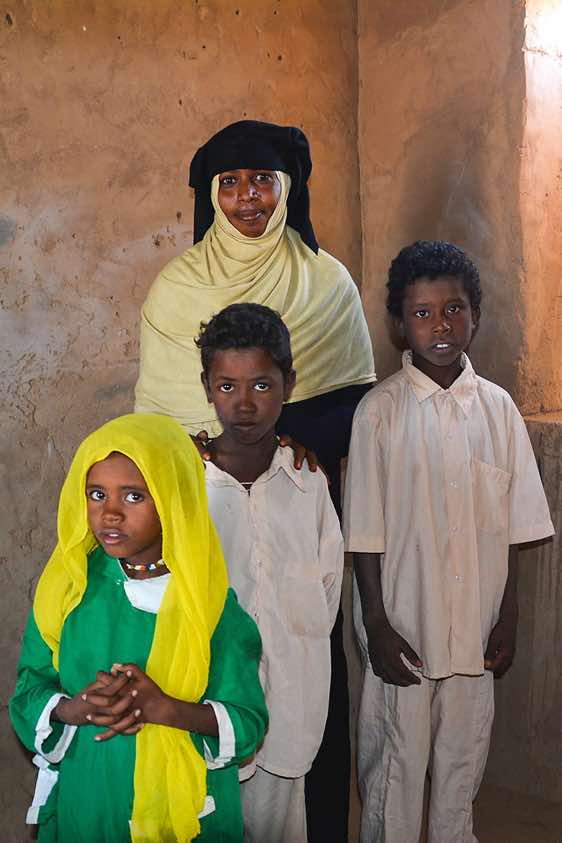 Unveiled local teacher and pupils at school, Bayuda Desert, Northern Sudan. Photo: Karin Scheidhammer