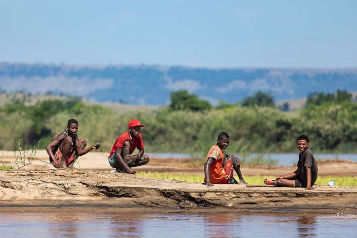 Group of men sitting on the banks of the Tsiribihina River, Western Madagascar