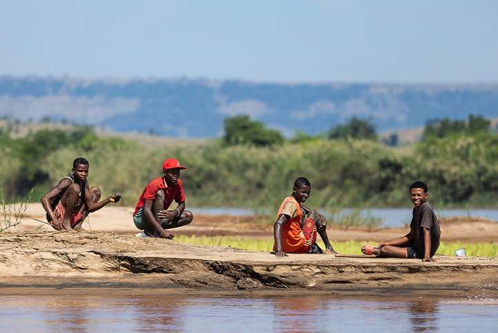 Group of men sitting on the banks of the Tsiribihina River, Western Madagascar