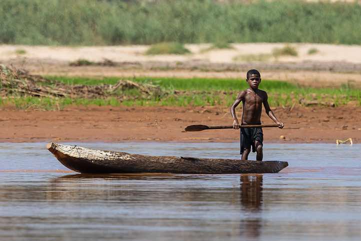 Young boy with his wooden canoe on the Tsiribihina River, Western Madagascar