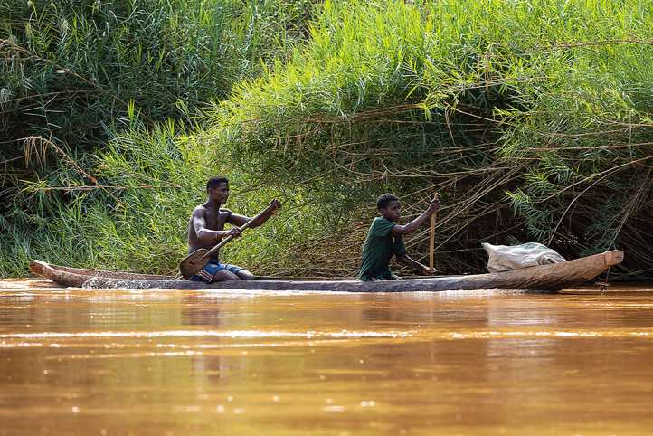 Men in a wooden canoe on the Tsiribihina River, Western Madagascar