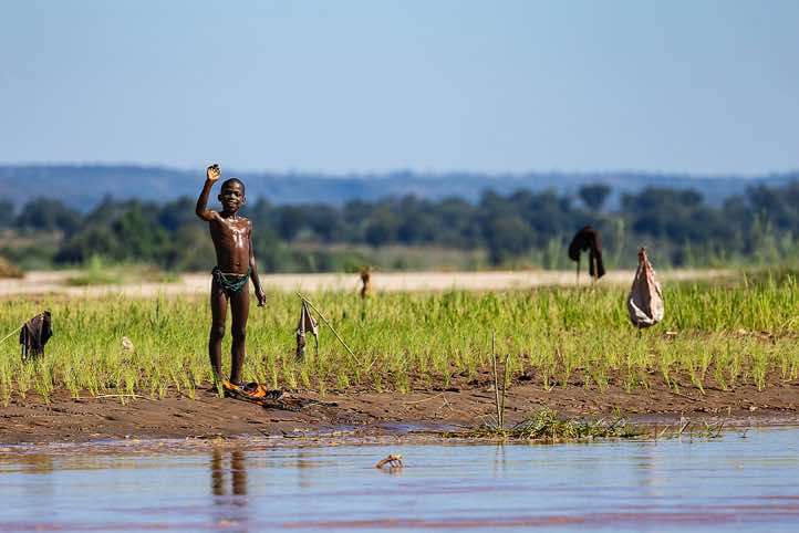 Young boy waving, Tsiribihina River, Western Madagascar