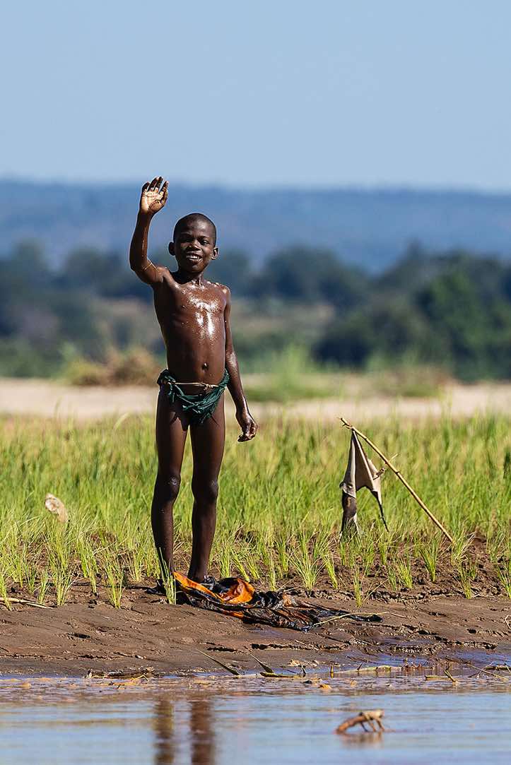 Young boy waving, Tsiribihina River, Western Madagascar