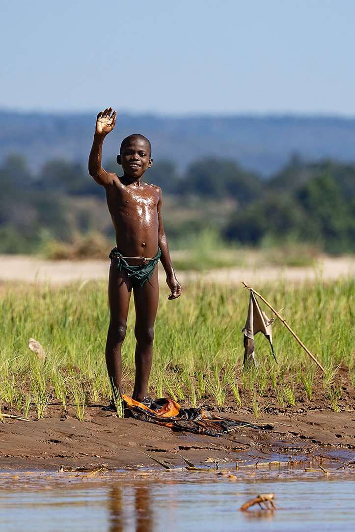 Young boy waving, Tsiribihina River, Western Madagascar