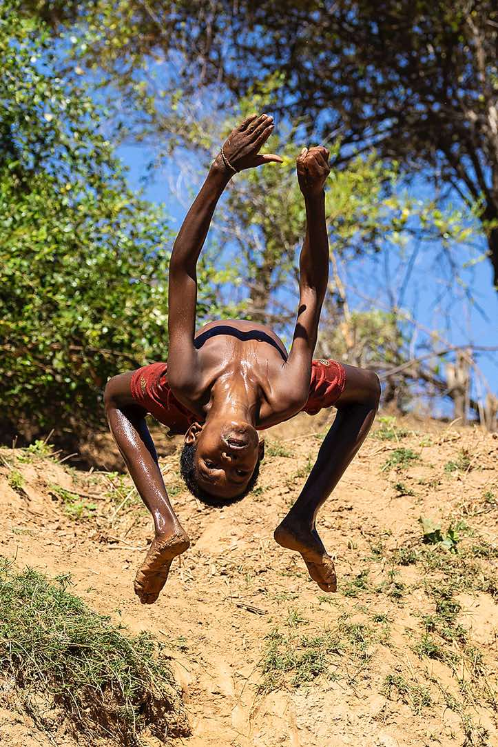 Young boy showing off his acrobatic skills, Tsiribihina River, Western Madagascar