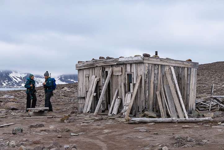 Expedition guides Isabelle Schulz and Nathalie Ansel standing in front of Raudfjordhytta, a historic trapper's hut, Alicehamna, Raudfjorden