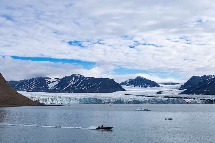 Zodiac shuttle in front of a glacier, near Valentinryggen landing site, St. Jonsfjorden