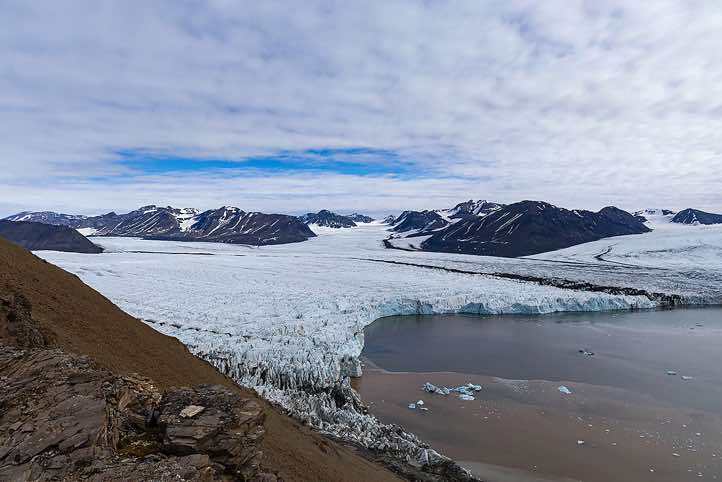 The merging glaciers Osbornebreen and Vintervegen flow into St. Jonsfjorden, Valentinryggen mountain ridge, Oscar II Land, Svalbarg