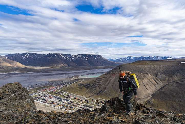 Guide Janina Popp on top of Platåfjellet. View of the central parts of Longyearbyen. The body of water is Adventfjorden while the valley up to the right is Adventdalen.